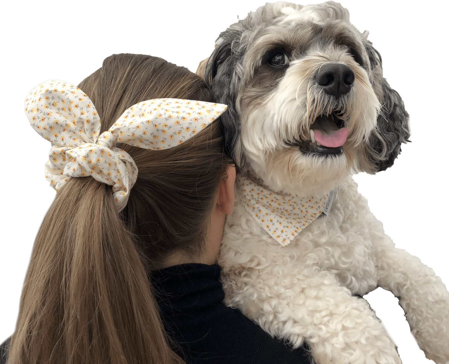 Dog wearing a flower bandana and woman wearing a flower scrunchie
